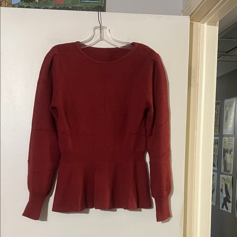 Deep red women’s round neck sweater. Peplum waist.